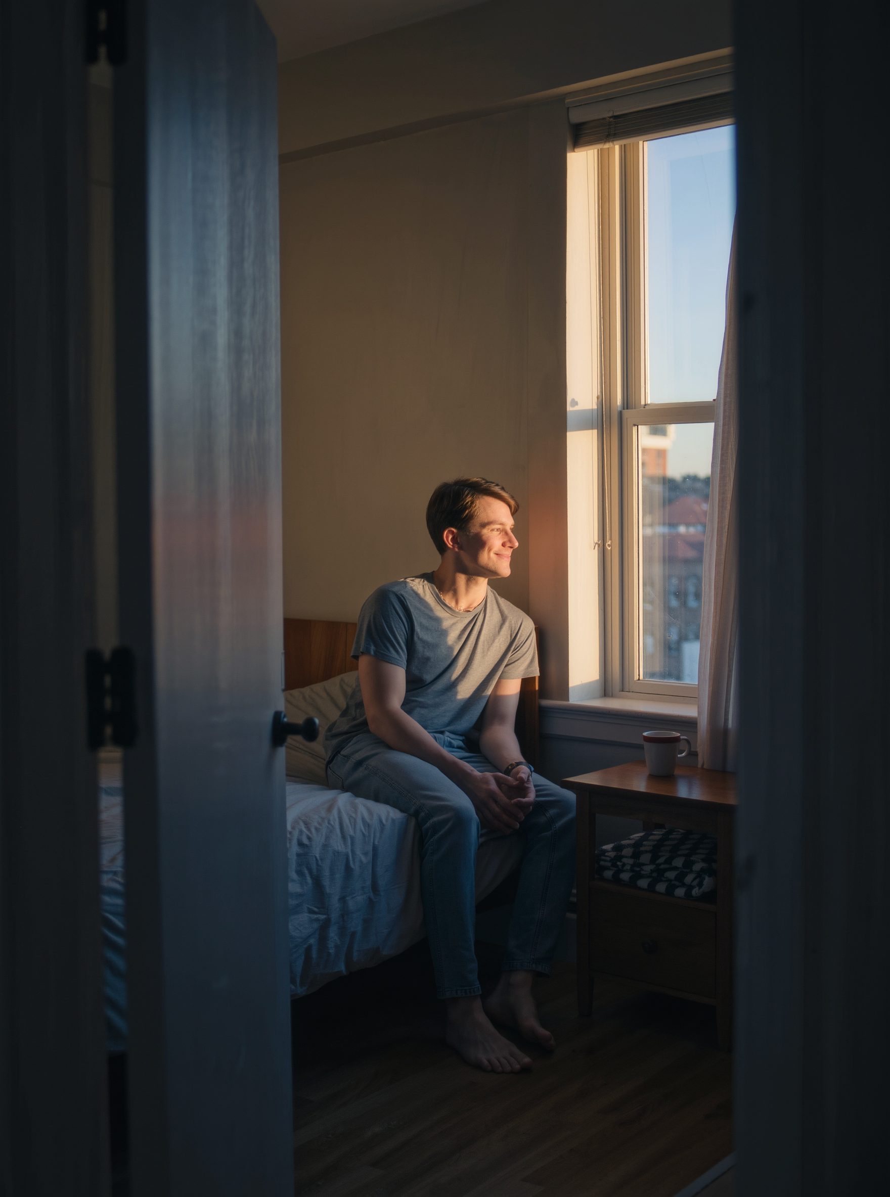 A young man by a window in late afternoon light